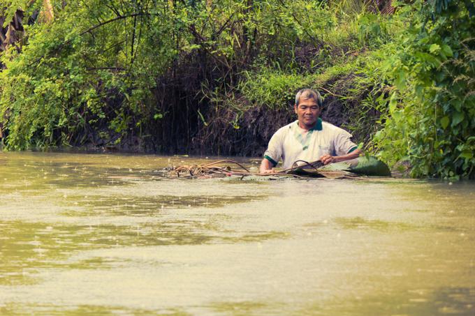 Can Tho City travel guide: A man setting his fishing net in the Mekong