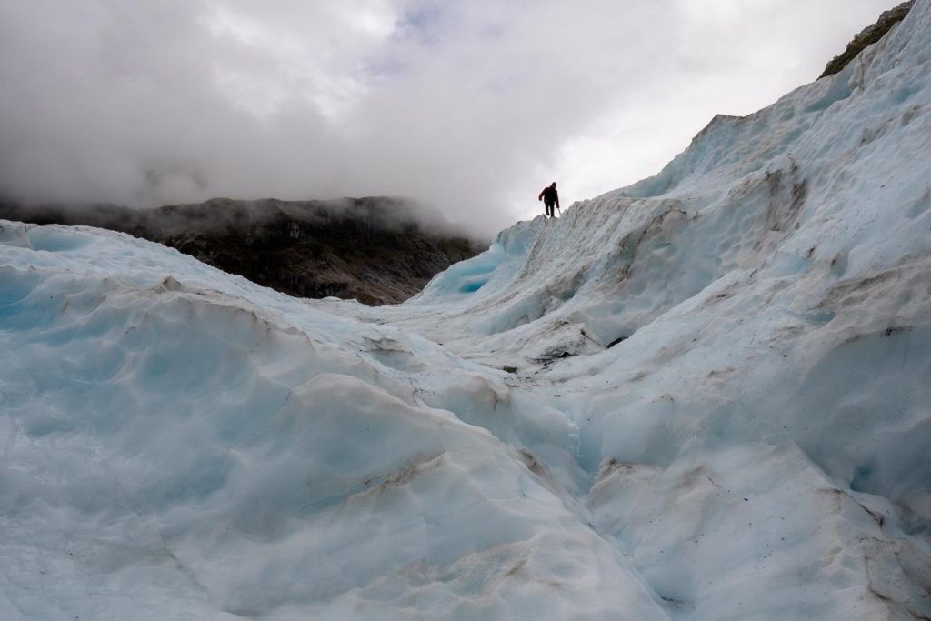 Man watching the weather on Fox Glacier 